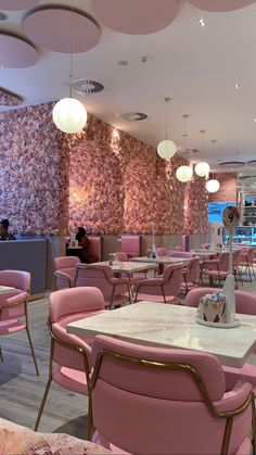 the interior of a restaurant with pink chairs and tables