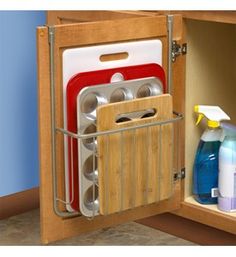 the kitchen cabinet door is open to show dishes and utensils in its holder