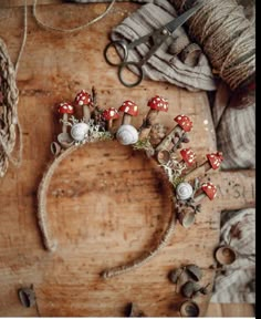 a headband made out of mushrooms and other items on a wooden table with scissors