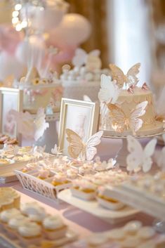 a table topped with lots of cakes and cupcakes