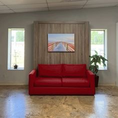 a red couch sitting in the middle of a living room