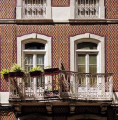 an apartment building with two balconies and flower boxes on the balcony