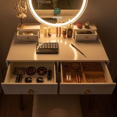 a vanity with a lighted mirror and various items on the counter in front of it