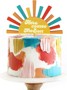 there is a cake that has been decorated with colorful icing and the words here comes nelson on it