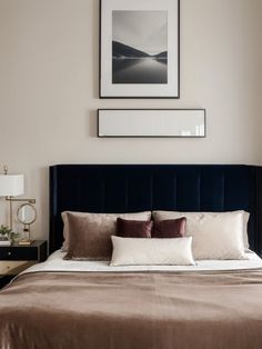 a bedroom with a bed, nightstands and pictures on the wall above it's headboard