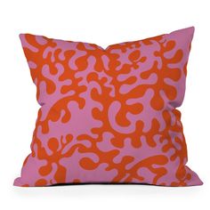 an orange and pink leopard print pillow sitting on top of a white floor next to a wall