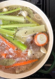 a pot filled with soup and vegetables on top of a stove