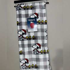 a towel hanging on a wall with a snoopy christmas pattern and santa's hat