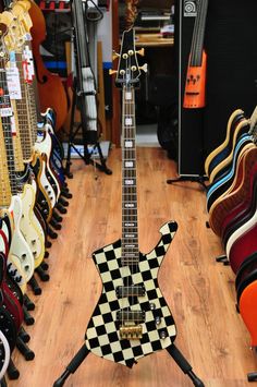 an electric guitar is sitting on display in a room filled with guitars and other musical instruments