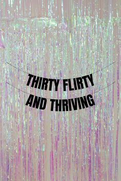 the words thirty flirty and thriving are hanging on a string in front of an abstract background