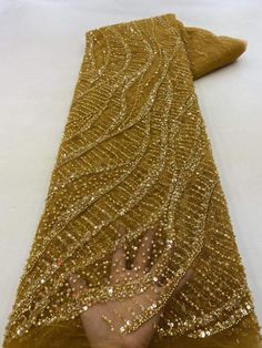 someone is holding their hand out in front of the gold sequins on this dress