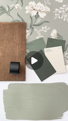 some paint swatches are laying on top of a wooden board with a video player