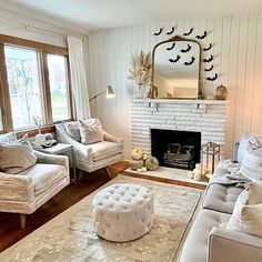 a living room with couches, chairs and a fire place in the center area