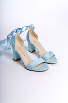 a pair of blue high heeled shoes with a satin ribbon