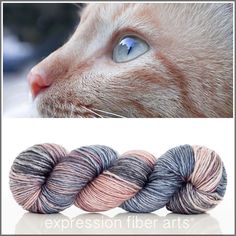 three skeins of yarn with an image of a cat's face in the background