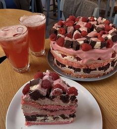 a piece of cake sitting on top of a white plate next to a glass of juice