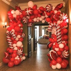 the balloon arch is decorated with candy canes and white and red balloons for an elegant look