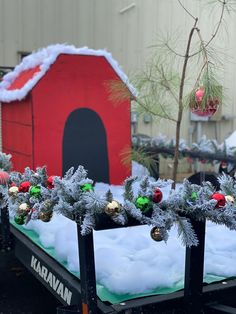 there are christmas decorations on the back of a flatbed trailer in front of a barn