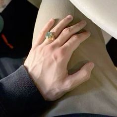 a person's hand on the back of a chair with a ring on it