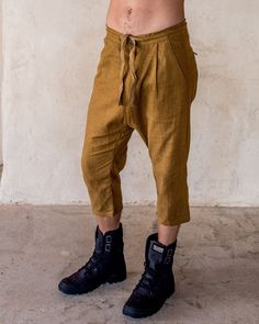 The IDIS Unisex linen pants in Tumeric. Our pants are constructed from a medium weight Linen, with big side pockets, zipped back pockets. button Fly and drawstring waist. slight drop crutch for the extra casual feels. Model wearing size Medium. Designer clothing that moves and evolves with you. Bringing you comfort and movability while maintaining a simple style. SIZE GUIDE XS: bust 88-94 cm | waist 66-72 cm | hips 78-82 cm S: bust 94-100 cm | waist 72-76 cm | hips 82-88 cm M: bust 100-106 cm | Brown Baggy Linen Bottoms, Linen Capris For Loungewear, Casual Linen Capri Pants, Linen Capri Pants With Pockets, Womens Onesie, Slouch Pants, Unisex Pants, Black Overalls, Dance Pants