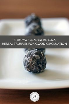 three black truffles on a white plate with the words warming winter rituals