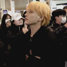 a group of people wearing face masks at an airport