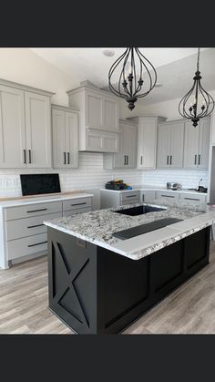 an image of a kitchen with white cabinets and granite counter tops in the center island