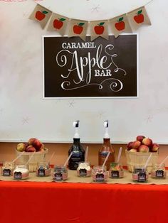 an apple bar is set up on a table with apples in baskets and caramel bottles