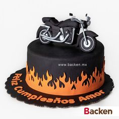 a black and orange motorcycle cake with flames on it