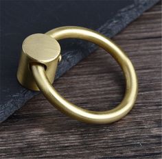 an image of a brass ring on a wooden surface with black slate board in the background