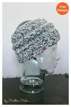 a crocheted hat sitting on top of a glass mannequin's head