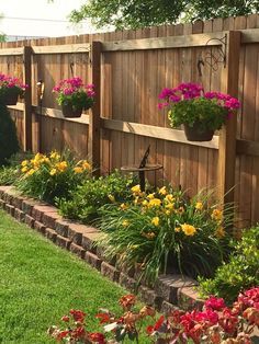 a wooden fence with flower pots on it and flowers growing in the planter boxes