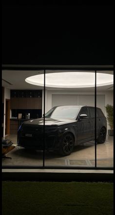 a car is parked in front of a round window that shows the inside of a house