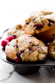 muffins and raspberries on a black plate