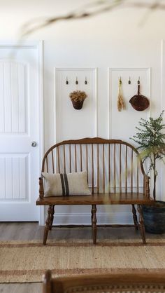 a wooden bench sitting next to a white door