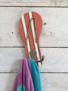 a towel hanging from a hook on a white wooden wall next to a pair of skis