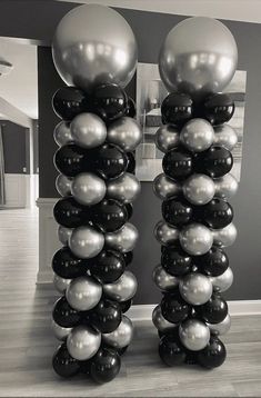 two tall black and white balloons in the middle of a room