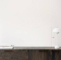 a white lamp sitting on top of a wooden dresser