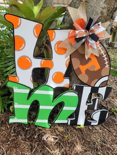 a wooden sign that says football and has the letter k on it in front of a tree