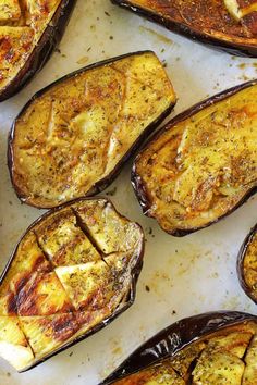 baked stuffed eggplant sitting on top of a baking sheet covered in seasoning