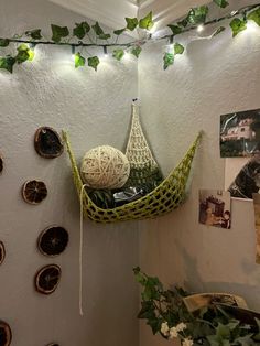 there is a green hammock hanging on the wall with string lights above it