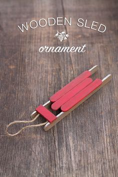 wooden sled ornament made from popsicle sticks on wood background with text overlay