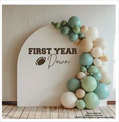 a balloon arch that says first year down with balloons in the shape of a football