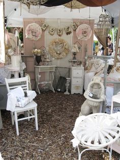 a room filled with lots of white furniture and decorations on the walls, including tables and chairs