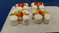 several marshmallows with gummy bears on them sitting on top of a piece of paper