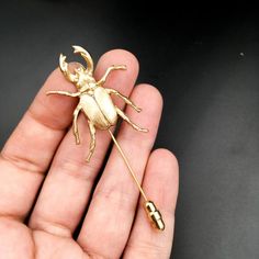 This golden brass stag beetle stick pin is handcrafted in the USA (Jersey City, New Jersey!)  The beetle itself is a brass stamping made from a vintage 1960's mold!  This insect stick pin can be worn as a lapel pin or even on a scarf!  The beetle itself is 1.5" long and the hand forged stick pin is a standard 2" long and comes with a pin clutch to secure the pin in place.These unisex brass beetle stick pins make the perfect gift for the stylish bug lover in your life. Insect pins make great gift Insect Jewelry Design, Gift For Groom, Beetle Insect, Stag Beetle, Brass Accessories, Insect Jewelry, Stick Pins, Jersey City, Groom Gift