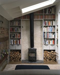 a living room filled with lots of books next to a fire place in front of a book shelf