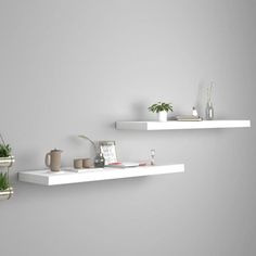 two white floating shelves with plants on them