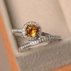 a yellow diamond ring sitting in a box