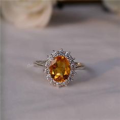 an orange and white diamond ring sitting on top of a table